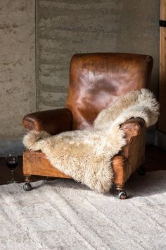 an old leather chair with a fur rug on the floor