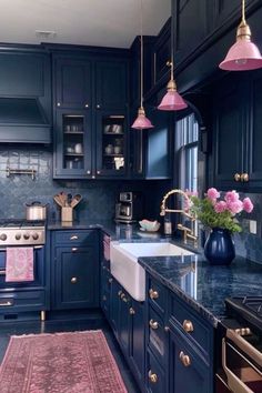 a kitchen with blue cabinets, pink rug and gold accents on the countertops is pictured in this image