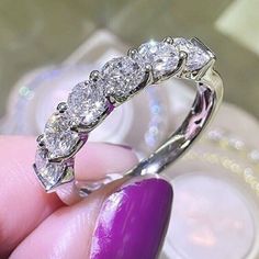 a woman's hand holding a diamond ring