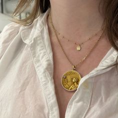 A dainty gold medal featuring the Virgin Mary on a gold station bead chain is the perfect layering piece for your collection! Delicate Gold-plated Yellow Gold Coin Necklace, Yellow Gold Plated Coin Necklace With Delicate Chain, Gold Plated Yellow Gold Coin Necklace With Delicate Chain, Yellow Gold Round Pendant Necklace For Layering, Gold Plated Charm Necklace With Satellite Chain, Gold Charm Necklace With Satellite Chain For Everyday, Gold-plated Gold Charm Necklace With Satellite Chain, Gold Plated Charm Necklaces With Satellite Chain, Gold Plated Gold Charm Necklace With Satellite Chain