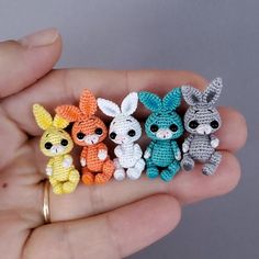 small crocheted animals are sitting in the palm of someone's hand