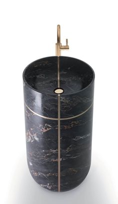 a black marble sink with gold accents