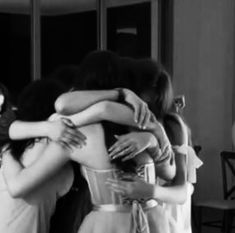 two women hugging each other in front of a mirror