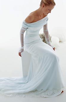 a woman in a long white dress posing for a photo with her hands on her hips