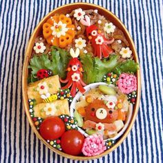 a bowl filled with lots of food on top of a blue and white table cloth