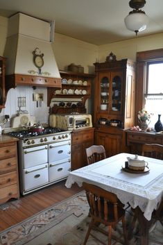 an old fashioned kitchen with white appliances and wooden cabinets, including a dining room table