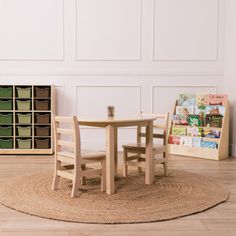 a wooden table and two chairs in a room with bookshelves on the wall