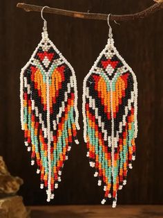 Add a touch of bohemian elegance to your style with these exquisite handmade glass bead earrings. Crafted with love and care, these intricate earrings feature a beautiful design showcasing a harmonious blend of orange, red, black, white, and turquoise beads. Inspired by American Indian and Indigenous designs, these earrings are perfect for adding a pop of color and a unique flair to any outfit. The stunning array of colors brings warmth and vibrancy, making these earrings a standout accessory for any occasion. Embrace the blend of boho chic and heartfelt artistry with these captivating earrings. Bohemian Beaded Earrings With Fringe, Bohemian Teardrop Beaded Earrings With Colorful Beads, Bohemian Teardrop Dangling Beads, Multicolor Beaded Fringe Chandelier Earrings As Gift, Bohemian Beaded Earrings With Large Beads, Traditional Multicolor Beaded Fringe Tassel Earrings, Traditional Multicolor Beaded Earrings With Tassels, Traditional Multicolor Beaded Tassel Earrings, Artisan Multicolor Beaded Tassel Earrings