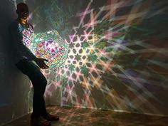 a man standing in front of a wall with lights on it