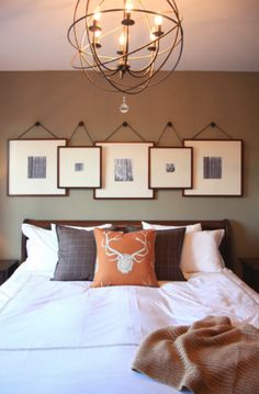 a bed with pillows and pictures hanging on the wall