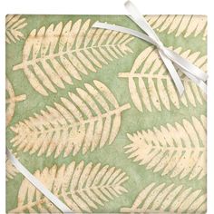 a wrapping paper with white leaves on it and a ribbon tied around the edge,