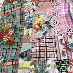 a patchwork quilt with many different patterns and colors, including flowers on the edges