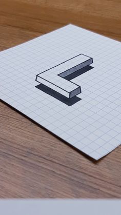 a piece of paper with the letter e on it sitting on top of a wooden table