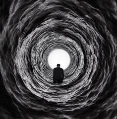 a man is standing in the middle of a black and white tunnel that looks like it has