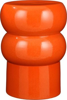 an orange vase sitting on top of a white surface