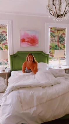 a woman laying on top of a bed in a bedroom