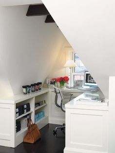 an office with white walls and black flooring in the corner, along with a computer desk