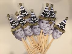 a group of people with hats on top of toothpicks in front of a wall