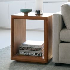 a table with books on it next to a couch in a living room or bedroom