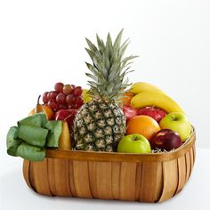 a wooden basket filled with lots of different types of fruit