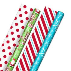 three christmas wrapping paper rolls lined up on top of each other with snowflakes and candy canes