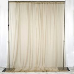 an empty room with a white curtain in the center and black metal frame around it