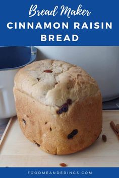 a loaf of bread sitting on top of a cutting board with raisins around it