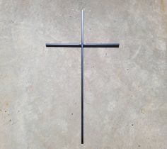 a metal cross sitting on top of a cement floor