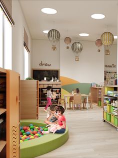 two children playing in a play room with toys