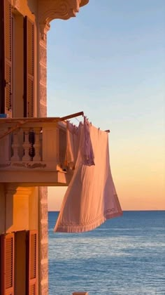 clothes hanging out to dry on the balcony overlooking the ocean at sunset or sunrise time