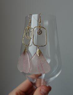 Discover elegance in these artisanal resin earrings made with real flower petals. Each piece captures nature's beauty and craftsmanship, featuring duo of pink petals, enchanted with unique moon charm and stylish geometric connectors. Key Features: - Real pressed flower petals (please, let me know if you know the name!) - Moon charm with sparkly crystals - Geometric connectors - Versatile for any occasion - Lightweight and comfortable Packaging: These earrings arrive nestled in a white organza po Flower Statement Earrings, Sparkly Crystals, Pink Petals, Moon Charm, Resin Earrings, Pressed Flower, Uv Resin, Flower Petals, Real Flowers