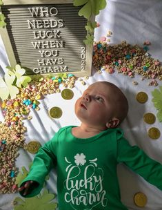 a baby laying on top of a bed covered in confetti next to a sign that reads who needs luck when you have crumbs