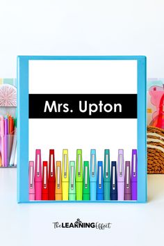 a blue frame with the words mrs upton in front of colorful crayons