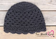 a gray crocheted hat sitting on top of a wooden table