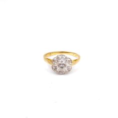 a gold and diamond ring on a white background with the center stone in the shape of a flower