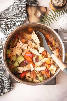 a pot filled with chicken and vegetables on top of a table