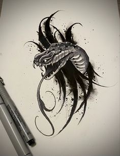 a black and white drawing of a dragon on paper next to a marker with ink