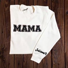 Mama sweatshirt with name sleeve.  Fleece with the word: MOM, MAMA, AUNTIE, GRANDMA or GIGI with textured letters and animal print offset. On the bottom backside of the sleeve goes the name of the kid or kid you would like to ad, followed by a heart. The sweaters are made to order so please allow 5-7 days for processing the order. If you want to make further customizations to the product please write them on the personalization text box or contact me within 48h of your oder. - Material: 50%cotto Personalized Long Sleeve Cotton Sweatshirt, Personalized Cotton Sweatshirt For Fall, Personalized White Cotton Hoodie, White Cotton Sweater With Name Print, Mother's Day Sweatshirt With Custom Text, Casual Sweatshirt With Custom Text For Mother's Day, Personalized Cotton Sweatshirt For Winter, Family Matching Long Sleeve Sweatshirt With Name Print, Cotton Long Sleeve Sweatshirt With Name Print