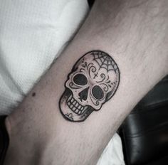 a man's arm with a tattoo on it that has a skull in the middle