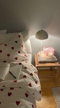 a bed room with a neatly made bed and a book on the nightstand next to it