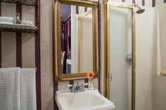 a bathroom sink sitting under a mirror next to a shower