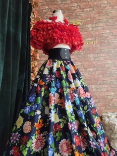 a dress on display in front of a brick wall with green curtains and red ruffles