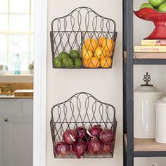 the magazine holder has fruit in it and is hanging on the wall next to shelves