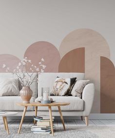 a white couch sitting next to a table on top of a rug in front of a wall