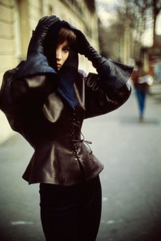 black and white photograph of a woman in a leather coat with hood on her head