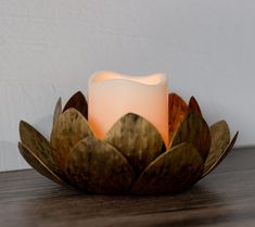 a lit candle sitting on top of a wooden table