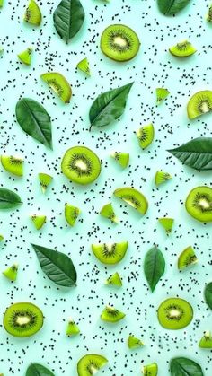 green kiwi slices and leaves on a blue background with speckles in the middle