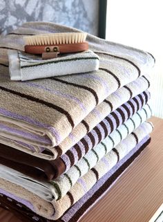 a pile of folded towels with a brush on top