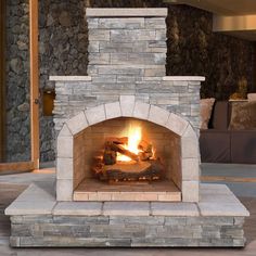 a stone fireplace with logs burning in it