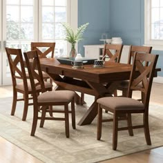 a dining room table and chairs with blue walls